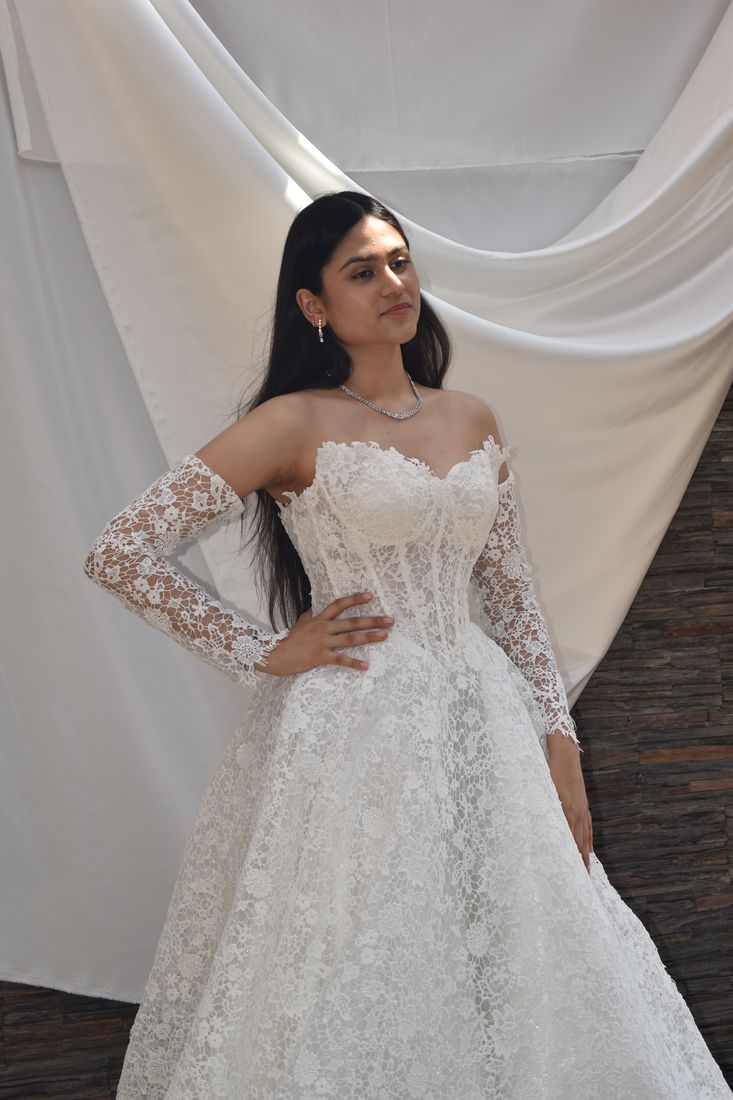 Bride in a lace corset gown with long detachable lace sleeves and mittens